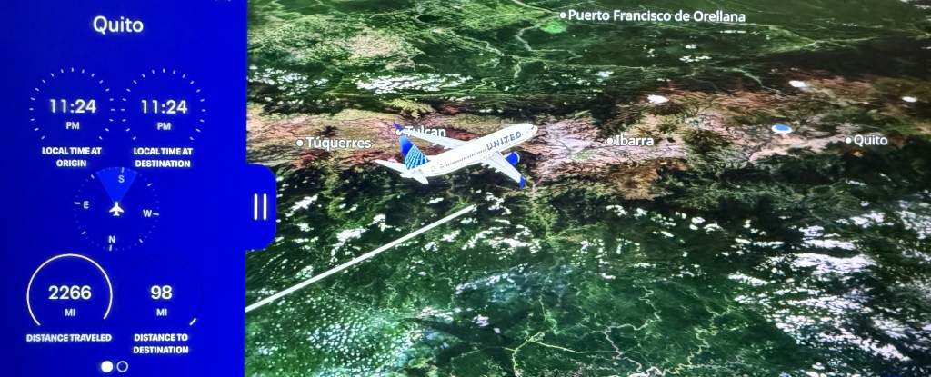 Flight map display showing Quito as the destination, with an airplane icon traveling over the landscape. Local times indicate 11:24 PM at both origin and destination. Distance traveled is 2266 miles with 98 miles remaining.